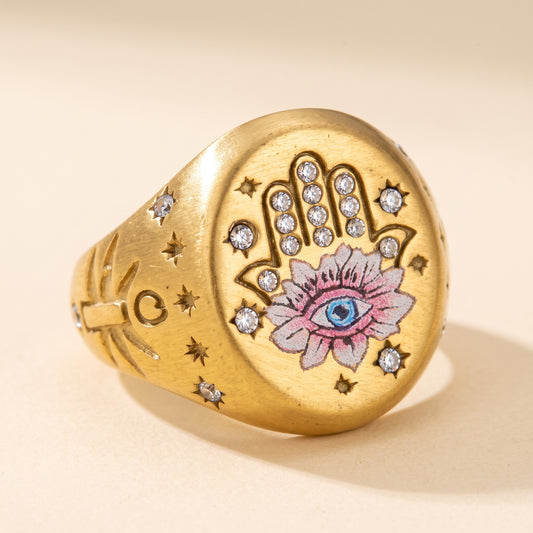Hamsa Eye signet ring in brushed gold, a stone-set hamsa hand with a painted lotus and blue eye
