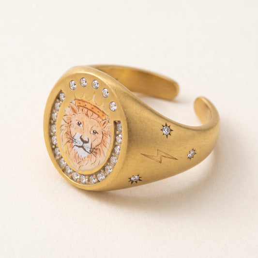 Lion Crest Ring, a gold-tone signet ring with an enamel lion's head framed by small stones