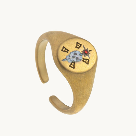 Memento Mori Ring, a gold-tone signet ring with an enamel skull and a single red stone