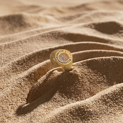Lion Crest Ring resting on sand